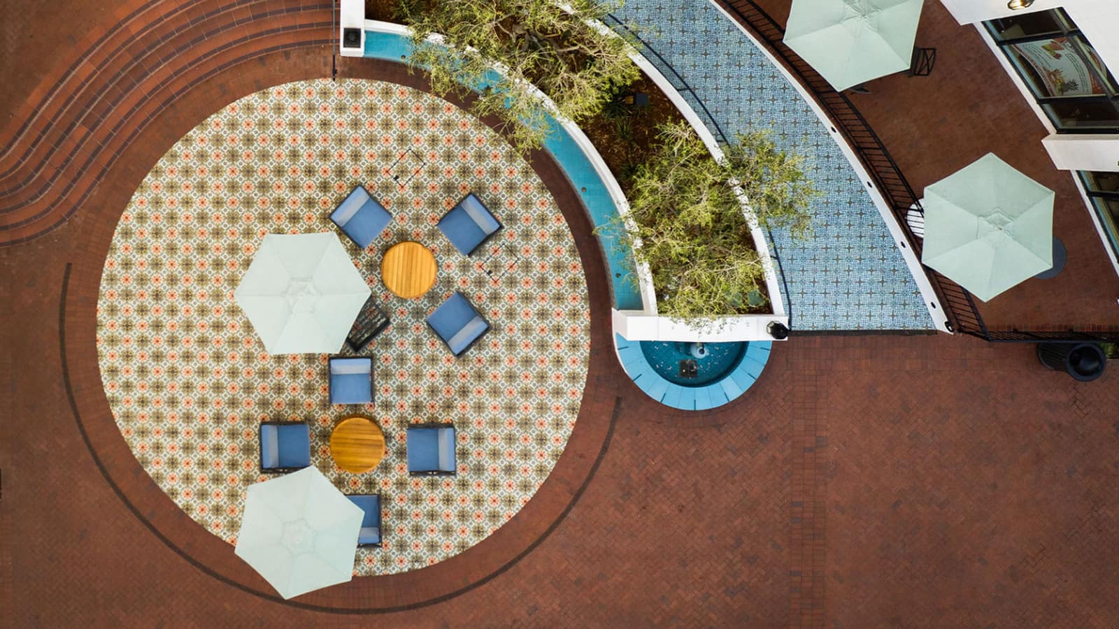 Aerial view of a California Pottery & Tile Works installation — patterned tile courtyard and pool surround.